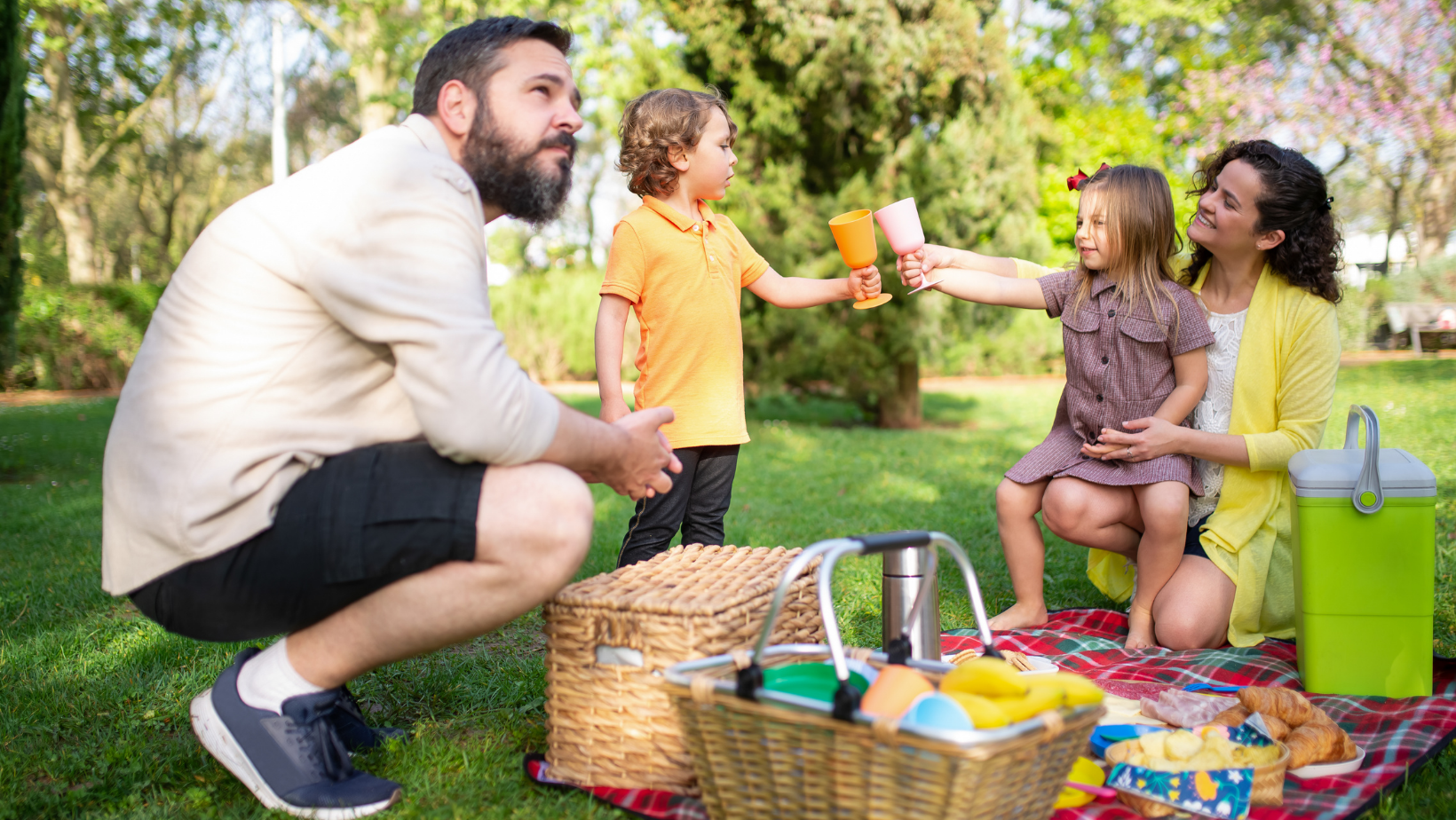 En familj som har en picknick på gräset