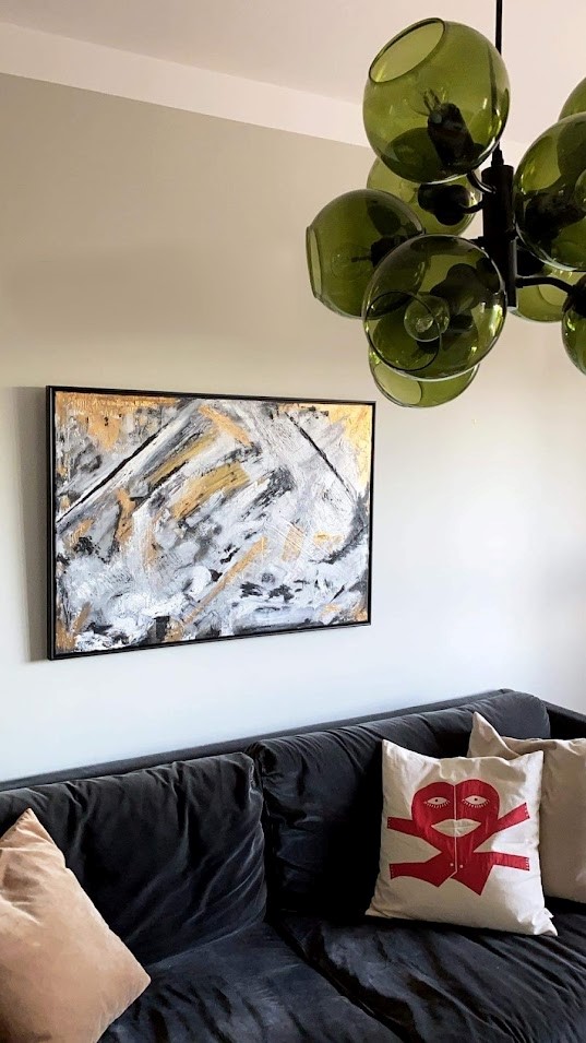 Bild på en abstrakt tavla ovanför en soffa