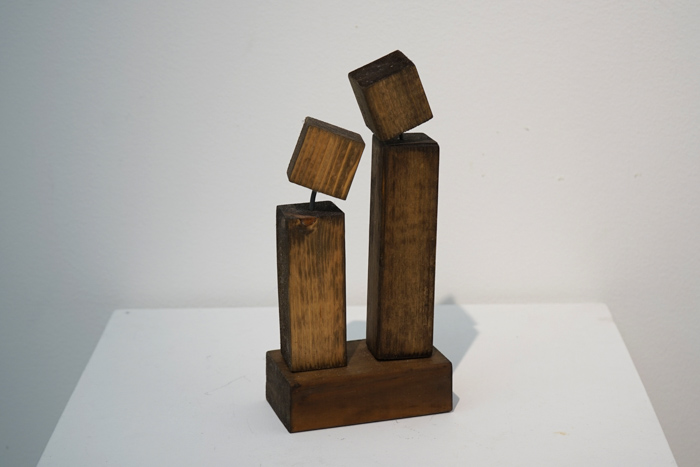 En skulptur i trä i två kroppar, en kortare och en längre