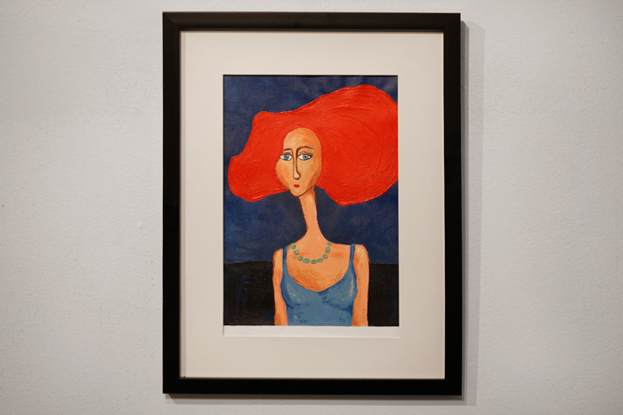En mindre målning föreställande en kvinna med stort rött hår