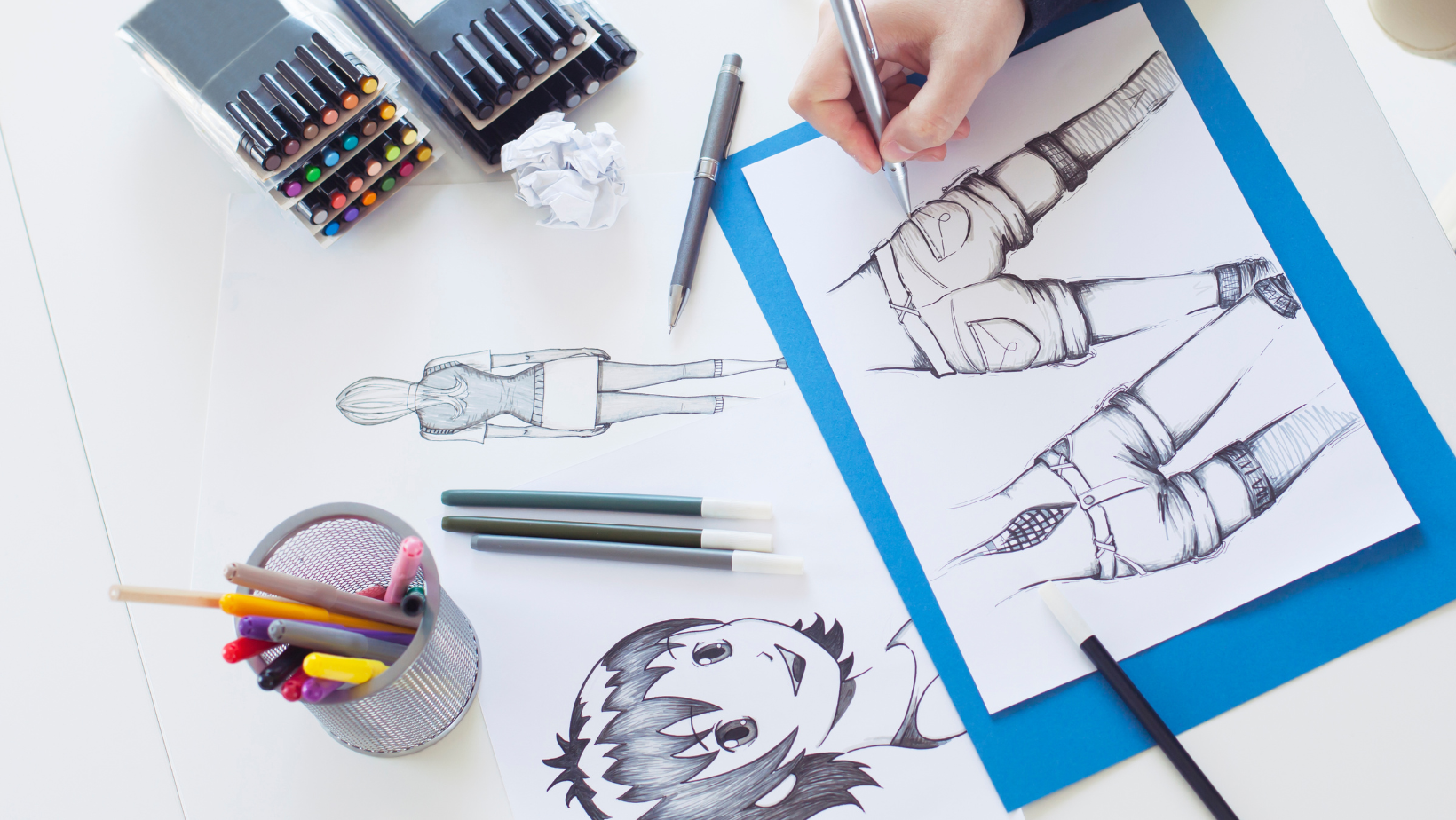 Konstnärsmaterial och en hand som målar manga-figurer