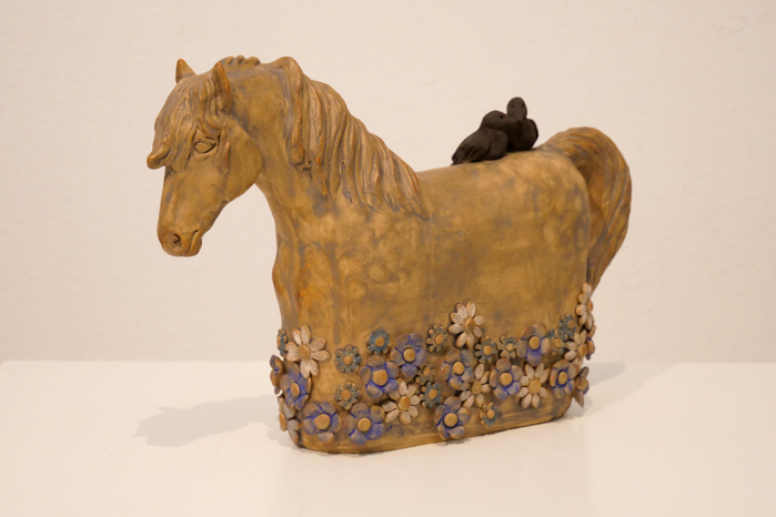 Skulptur föreställande häst stående i blommor